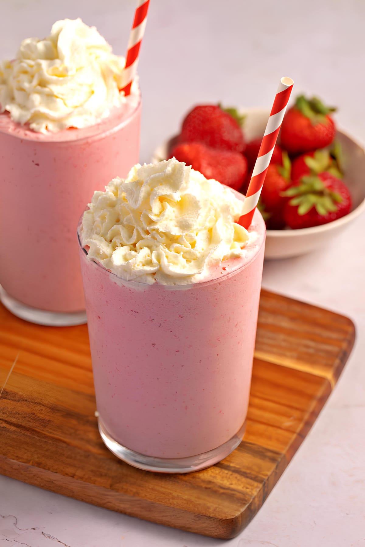 Creamy strawberry cappuccino on glasses served with whipped cream on top.