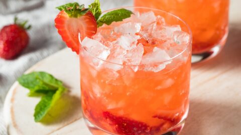 Strawberry gin cocktail with basil and sliced strawberries.