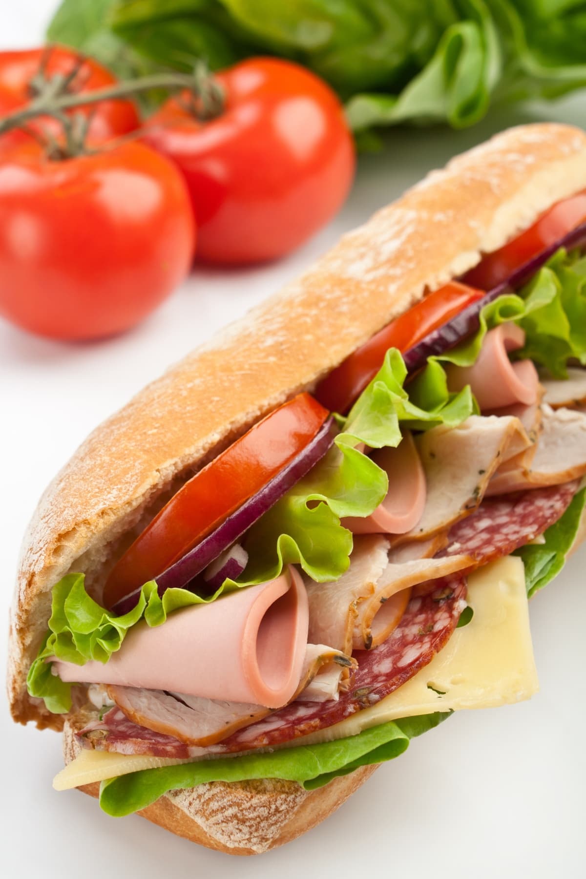 Subway baguette sandwich with lettuce, tomatoes, ham, turkey breast, salami and cheese.