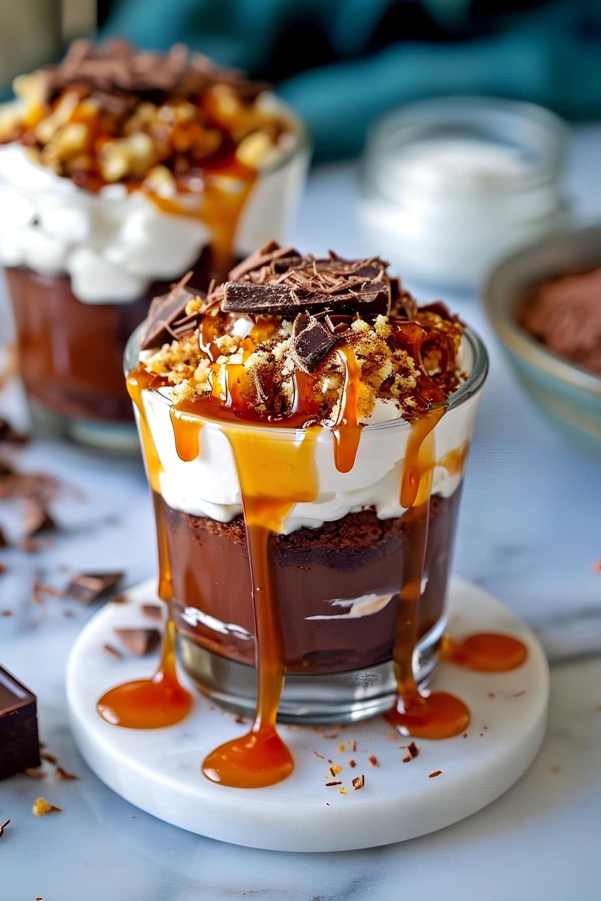Chocolate layered dessert in a cup topped with caramel syrup