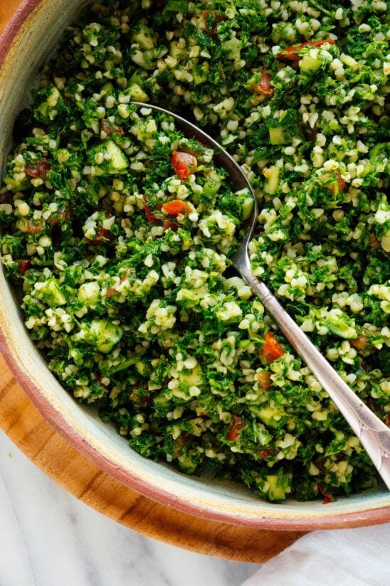 Bowl of tabbouleh mixed with a spoon. 