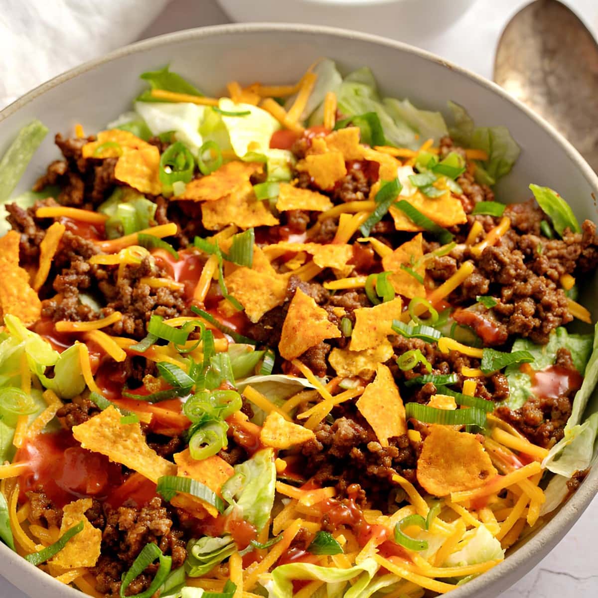 Taco Salad Close-Up Photo with ground beef, nacho's, cheese, and Catalina dressing