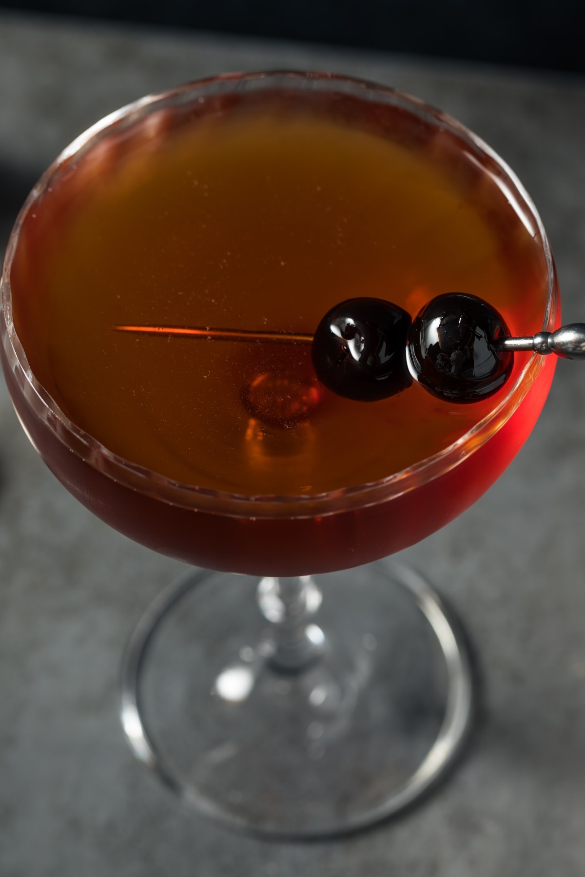 Top view of Brooklyn cocktail garnished with cherries on skewers served on a champagne glass. 