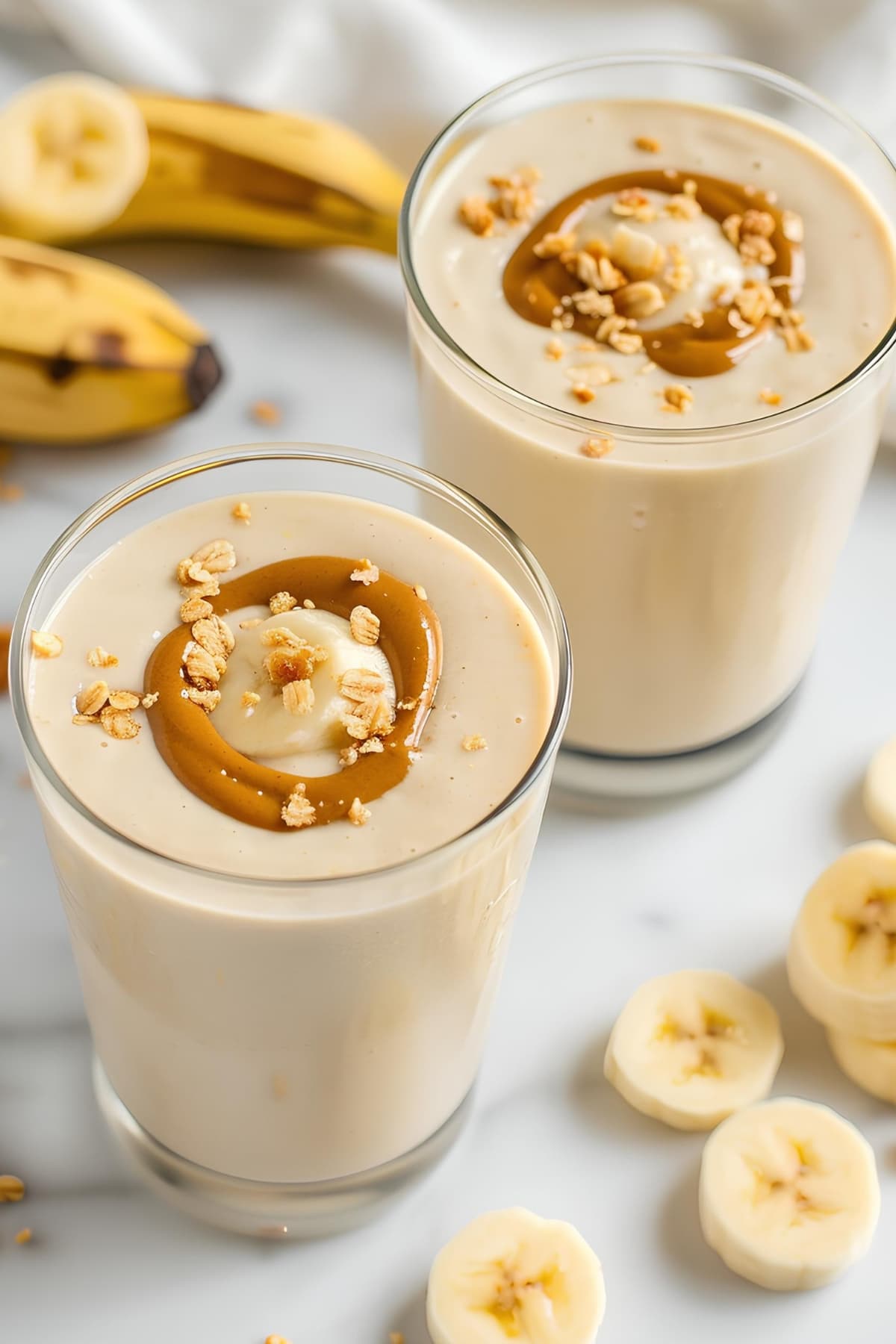 Two glasses of smoothie with bananas and peanut butter