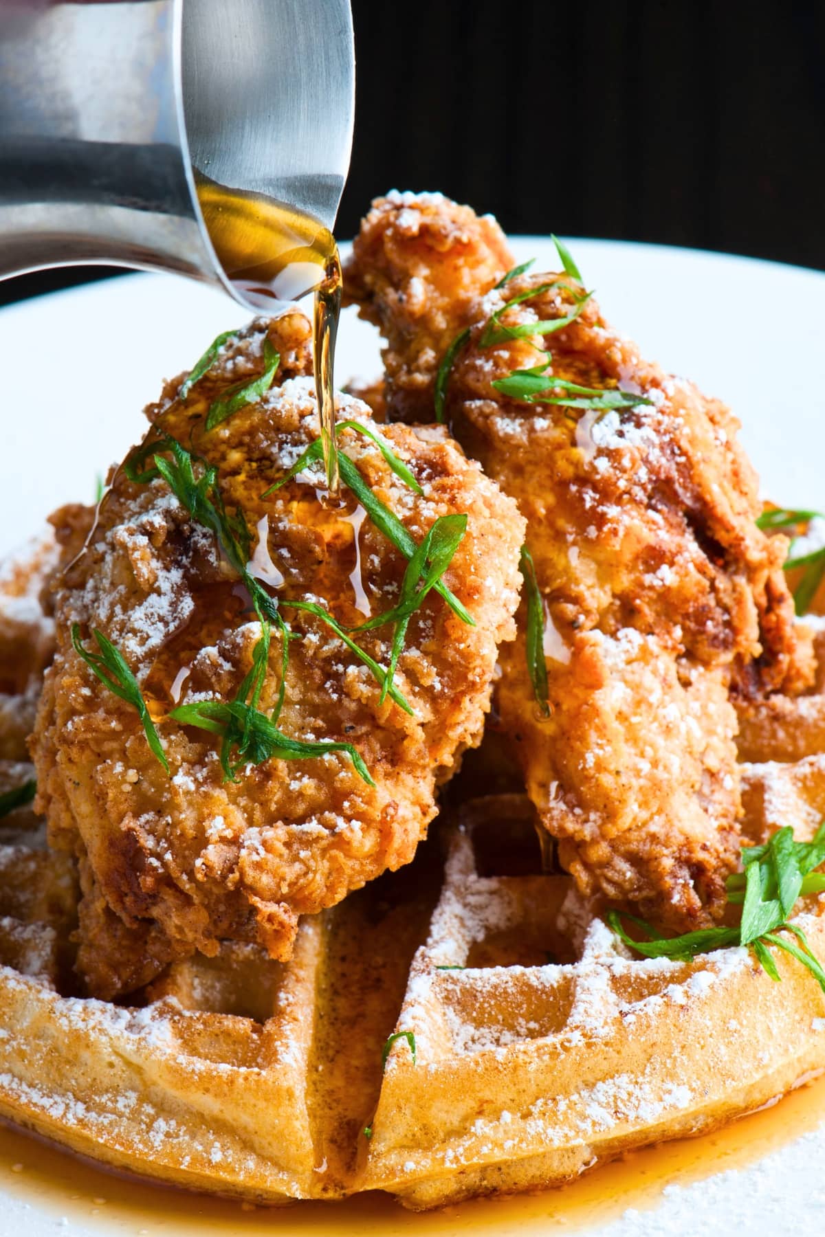 Waffles topped with fried chicken drizzled with maple syrup.
