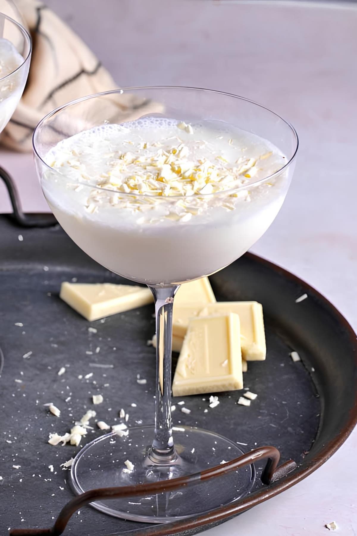 White chocolate martini served on cocktail glass with white chocolate shavings.