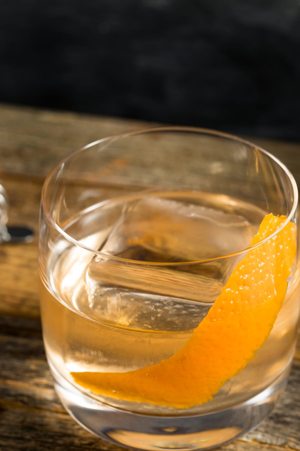 Closeup of Negroni cocktail with lemon peel garnished on the rocks. 