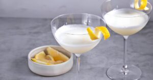 Wine glasses with white lady cocktail garnished with lemon twist.