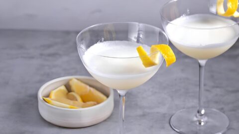 Wine glasses with white lady cocktail garnished with lemon twist.