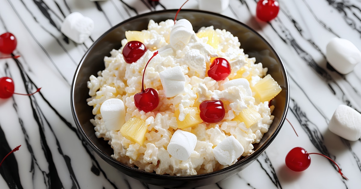A bowl of homemade glorified rice topped with cherries and marshmallows