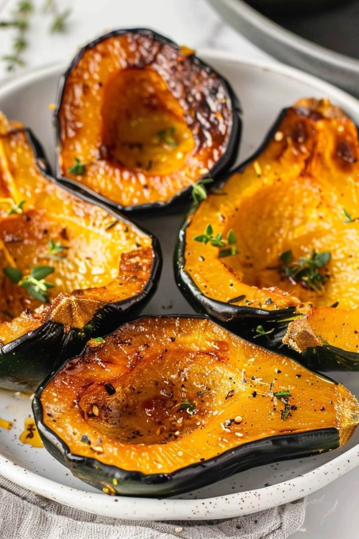 Air fried acorn squash sliced in halves in a white plate.
