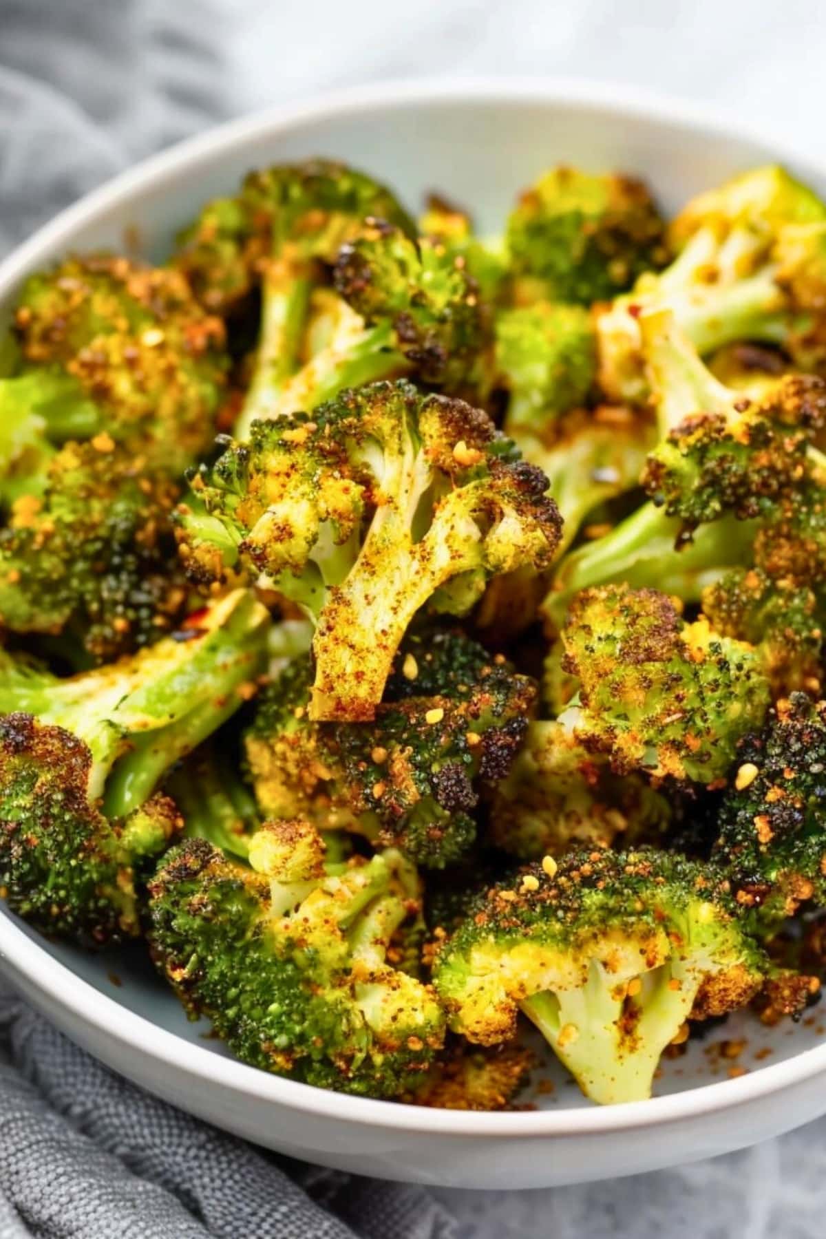 Bunch of air fried seasoned broccoli in a plate.