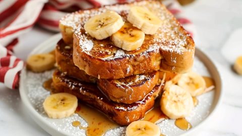 A stack of french toast with banana slices and cinnamon