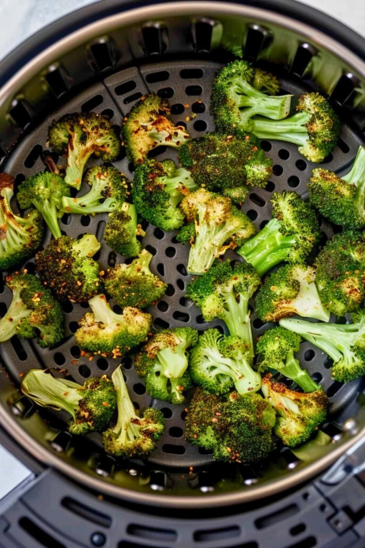 Broccoli florets inside an air fryer.