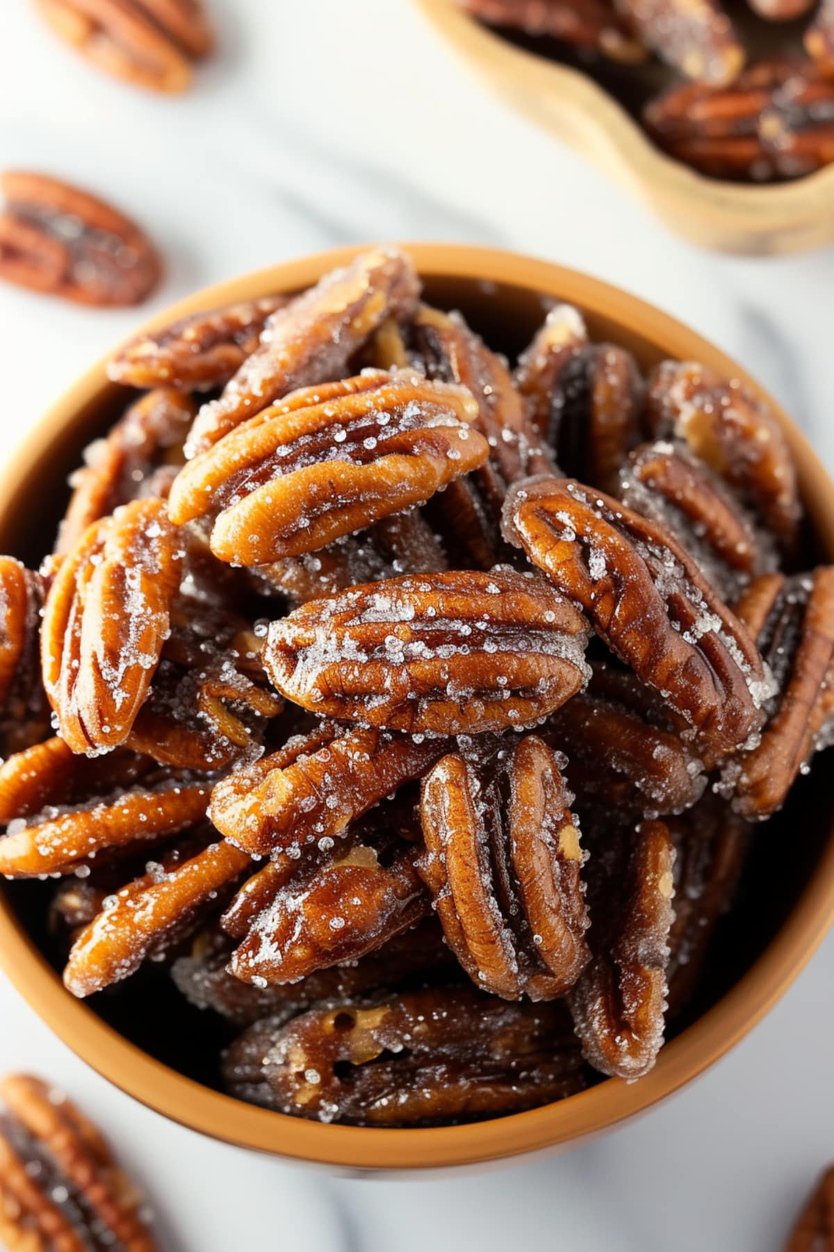 Top view of homemade candied pecans on  a brown bowl