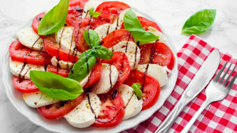 Caprese salad on a platter made with mozzarella cheese, tomatoes and basil.