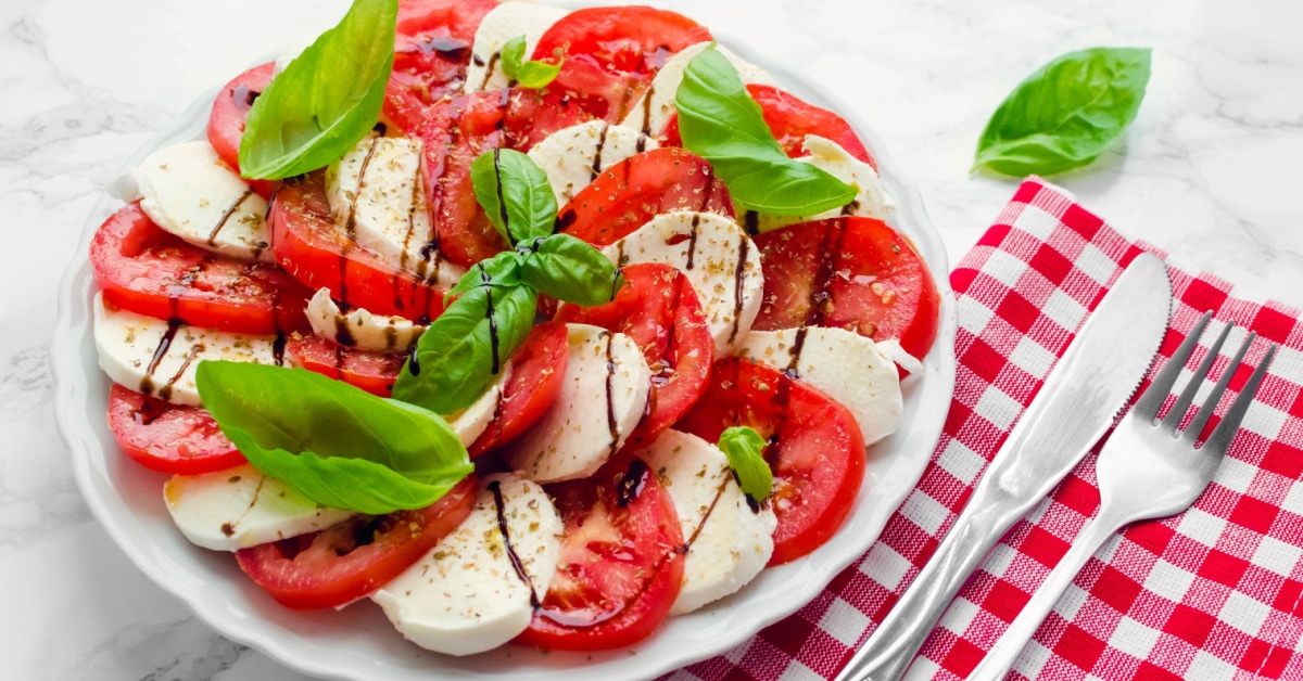 Caprese salad on a platter made with mozzarella cheese, tomatoes and basil.