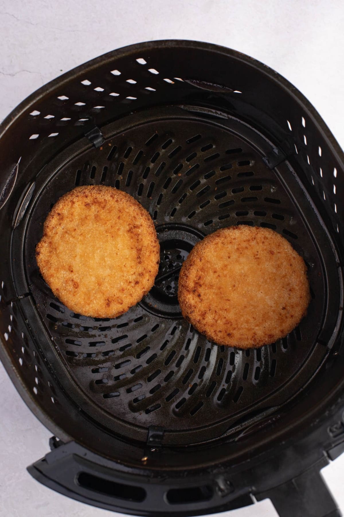 Two Tyson chicken patties in an air fryer