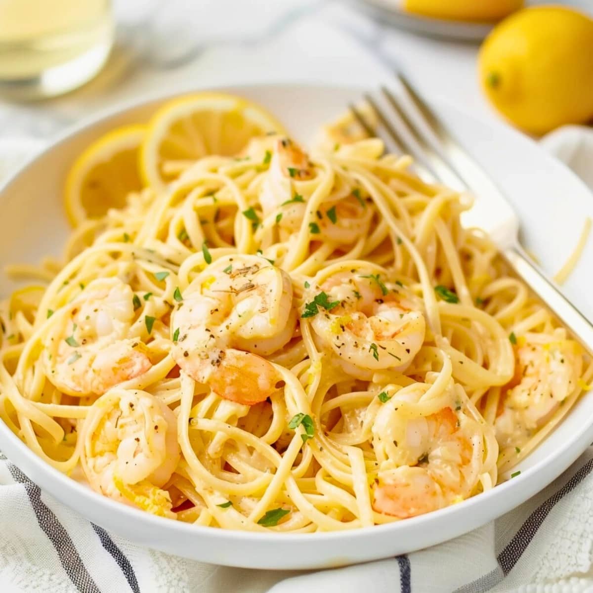 Creamy lemon shrimp pasta in a bowl with fork.