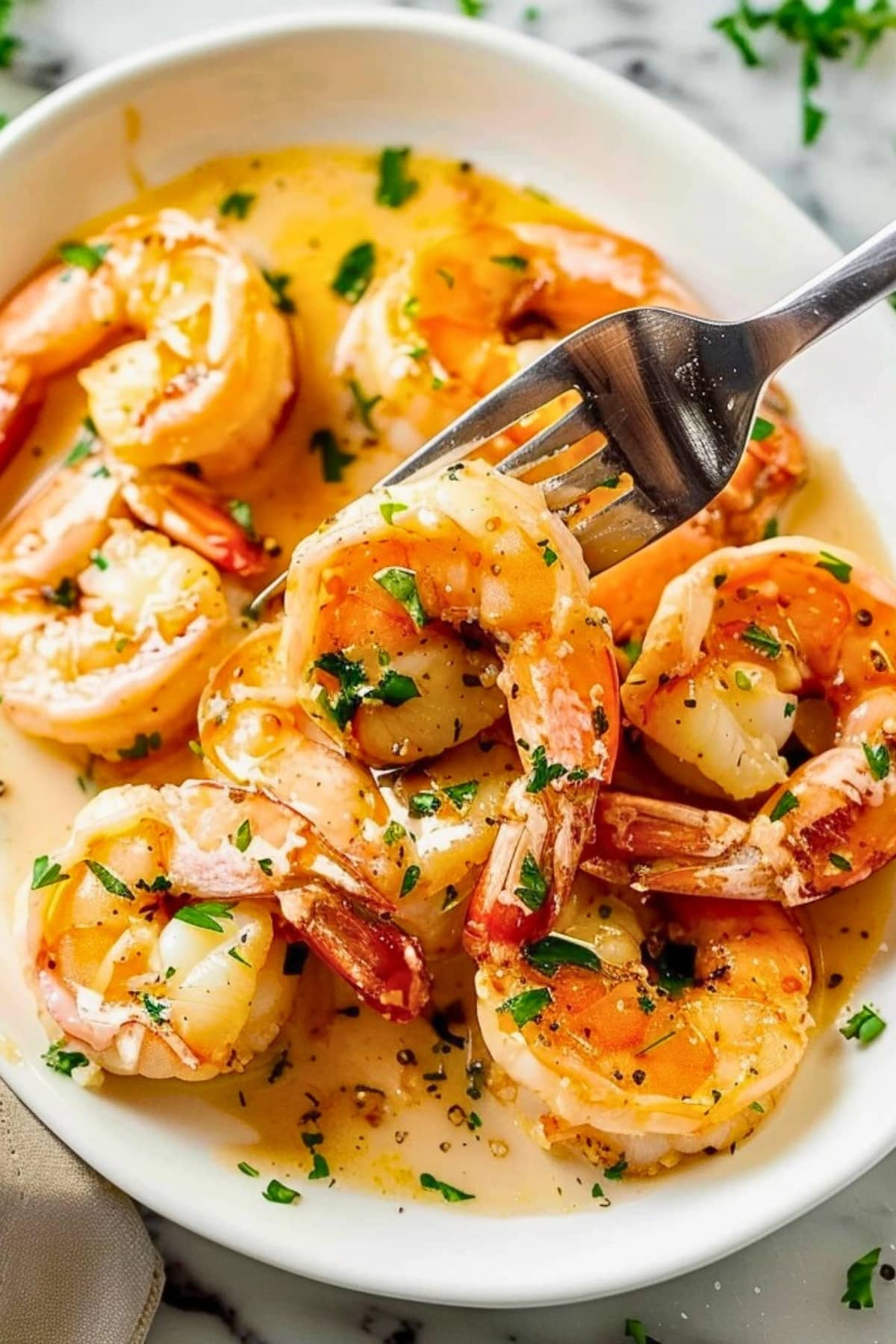 Shrimp with garlic butter sauce in a white plate.