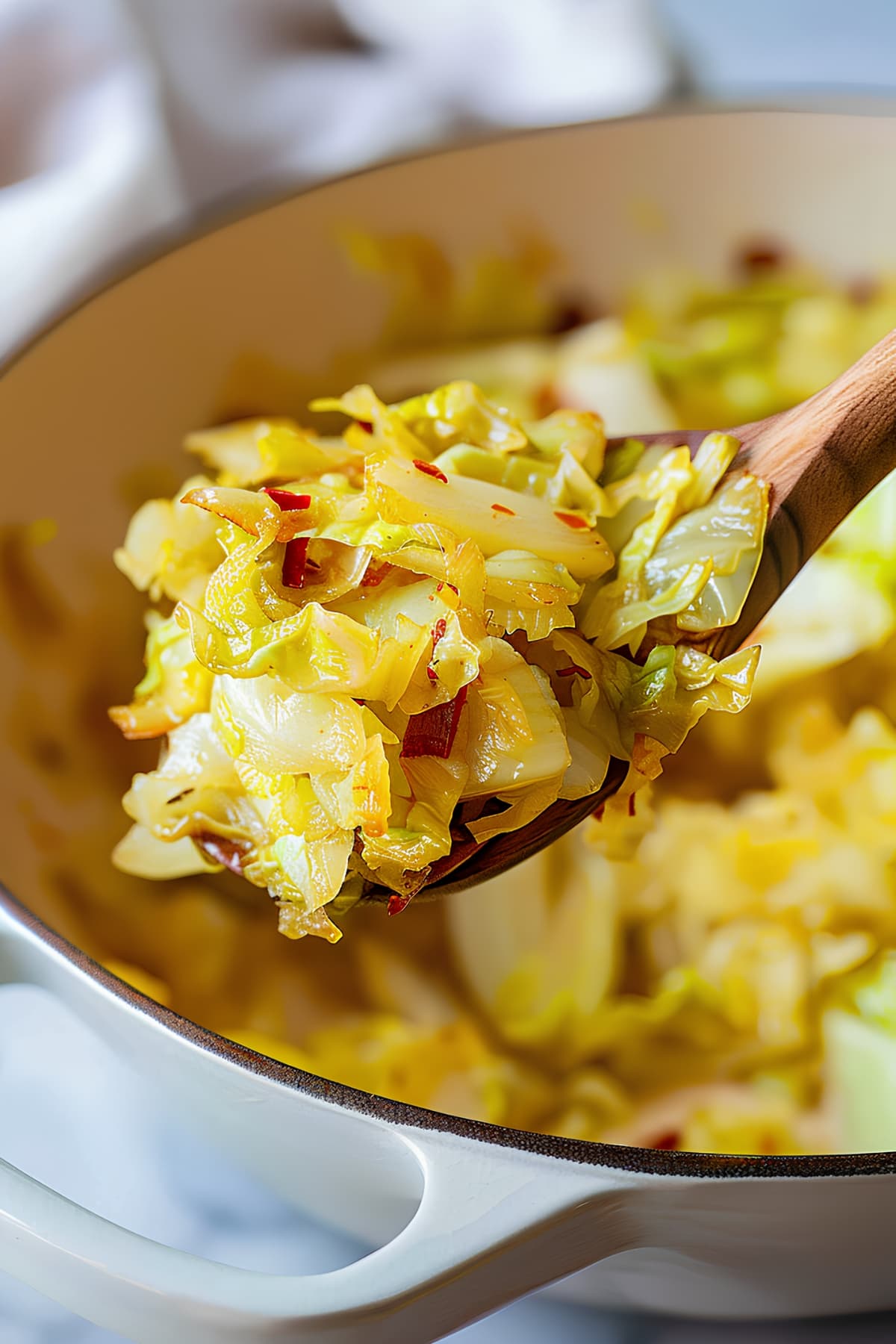 A spoon of fried cabbage with bacon
