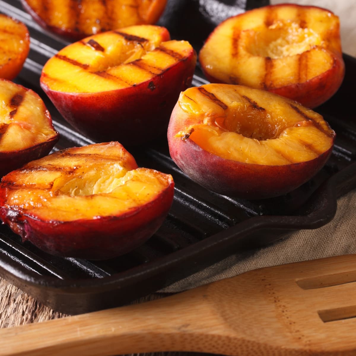 Grilled peaches on a grilling pan.