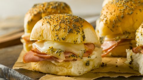 Bunch of sliced ham and cheese sliders.