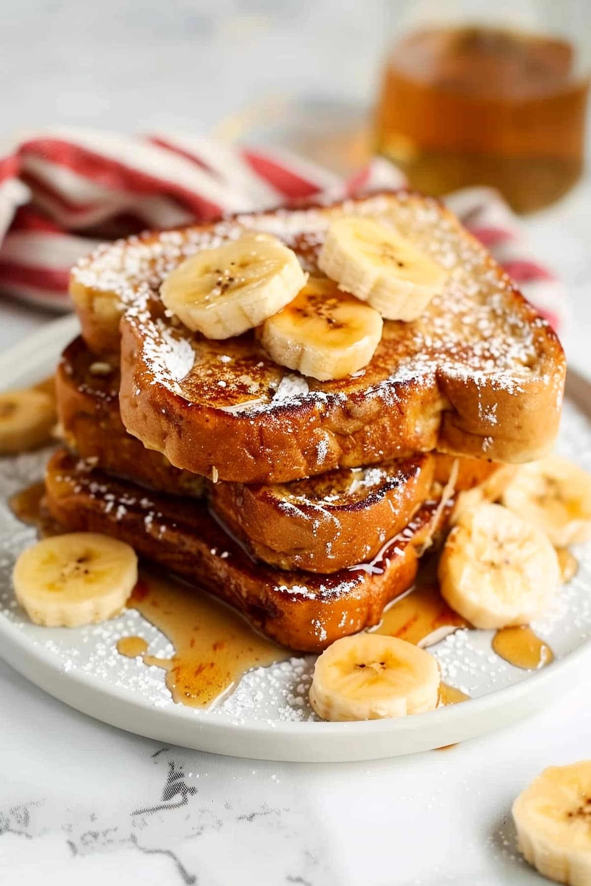 Homemade banana french toast with maple syrup and powdered sugar