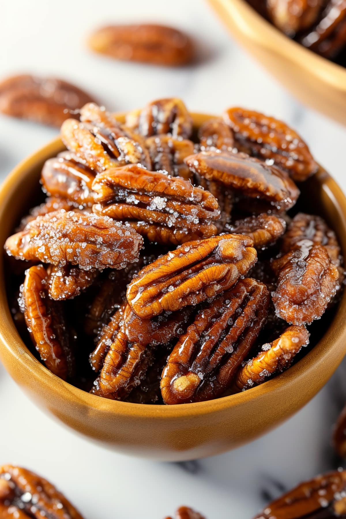 Sweet and salty homemade candied pecans in a brown bowl