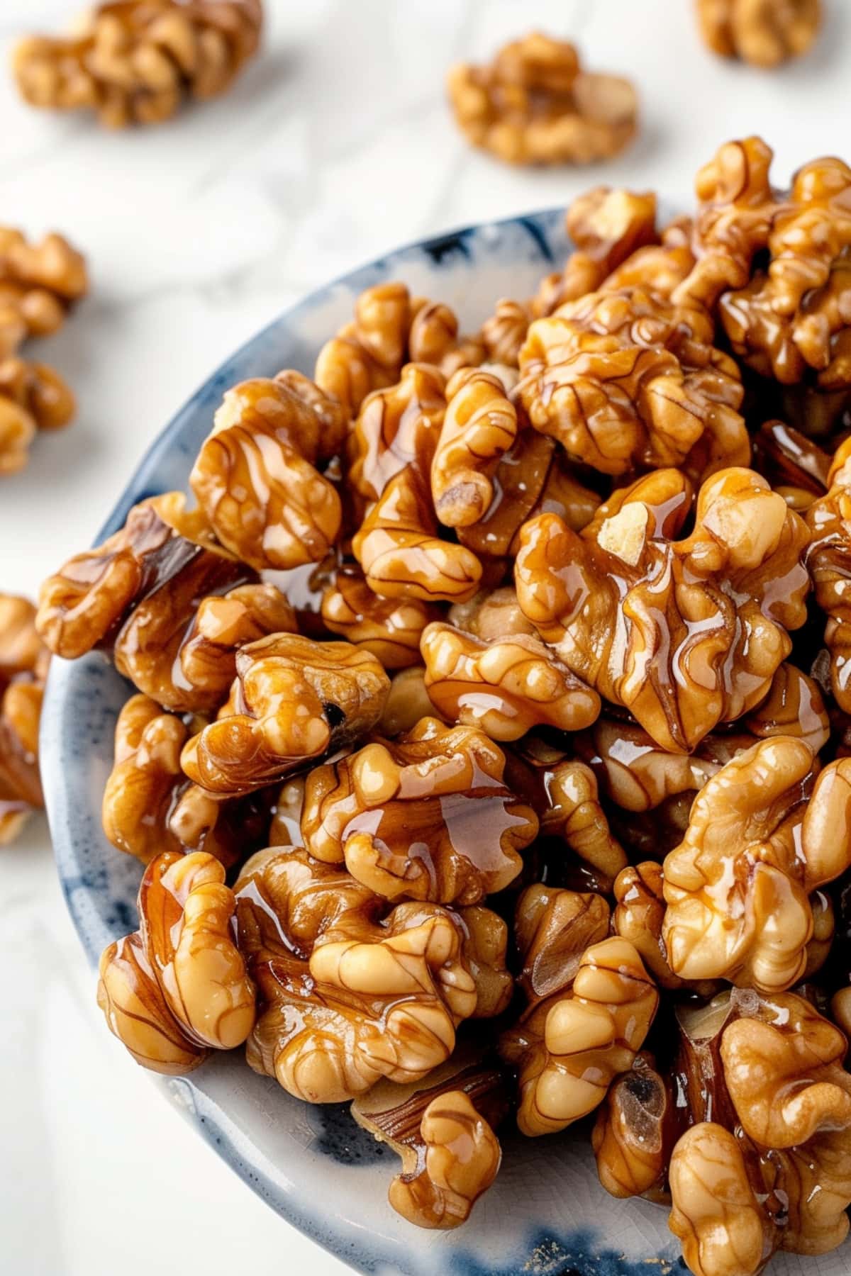 Sweet and buttery candied walnuts on a white marble table