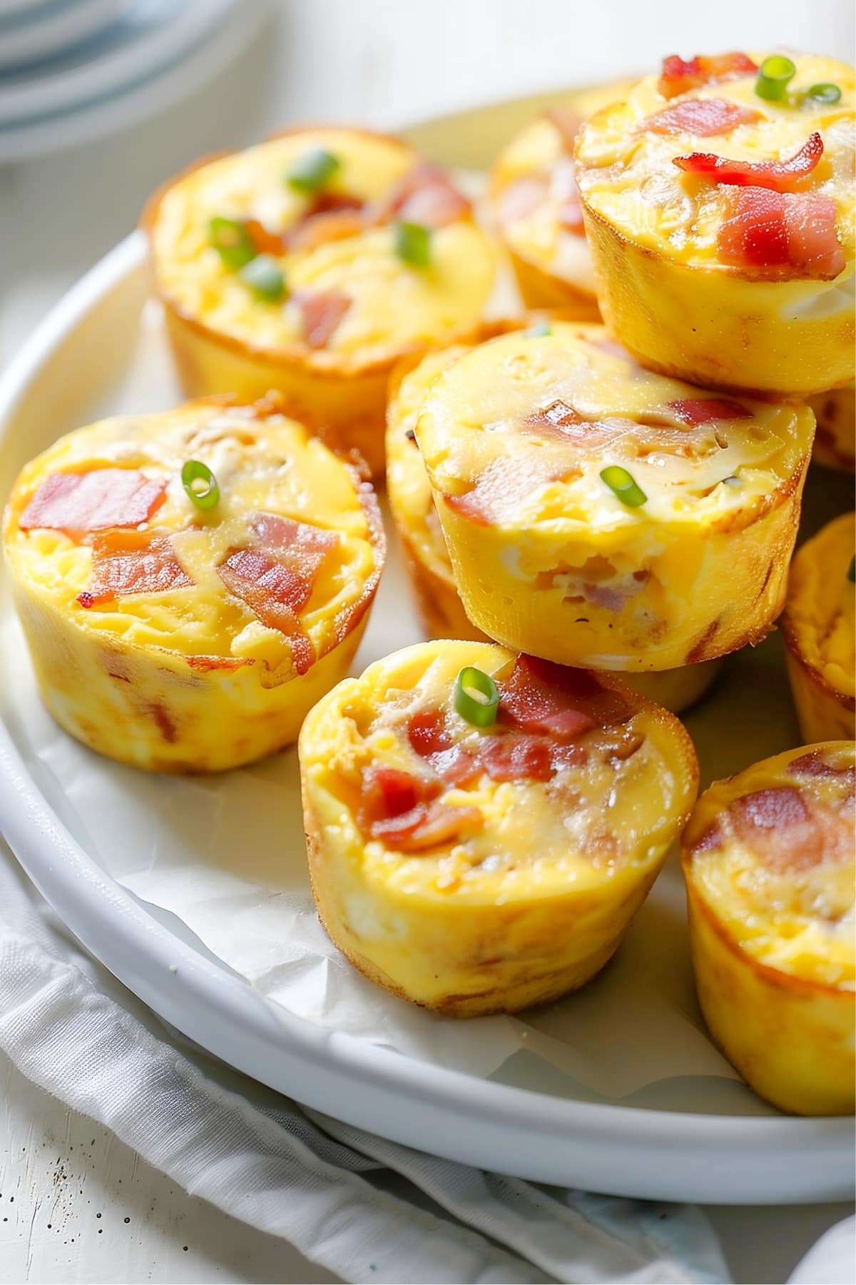 Mini egg bites filled with bacon, topped with green onions