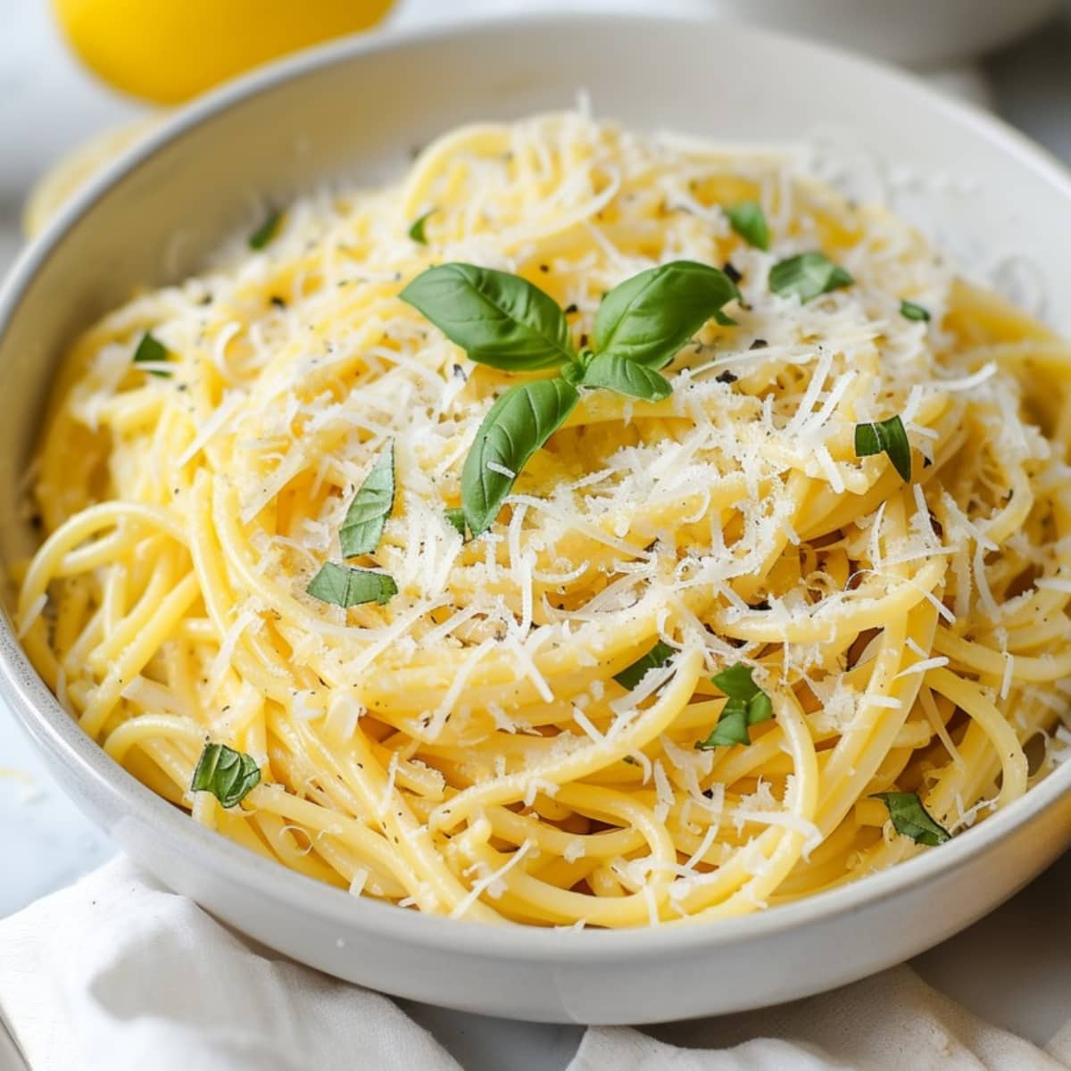 A savory pasta topped with basil, parmesan cheese and herbs in a bowl