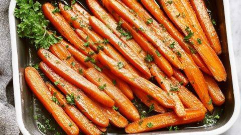 Honey glazed carrots arranged in a baking dish.