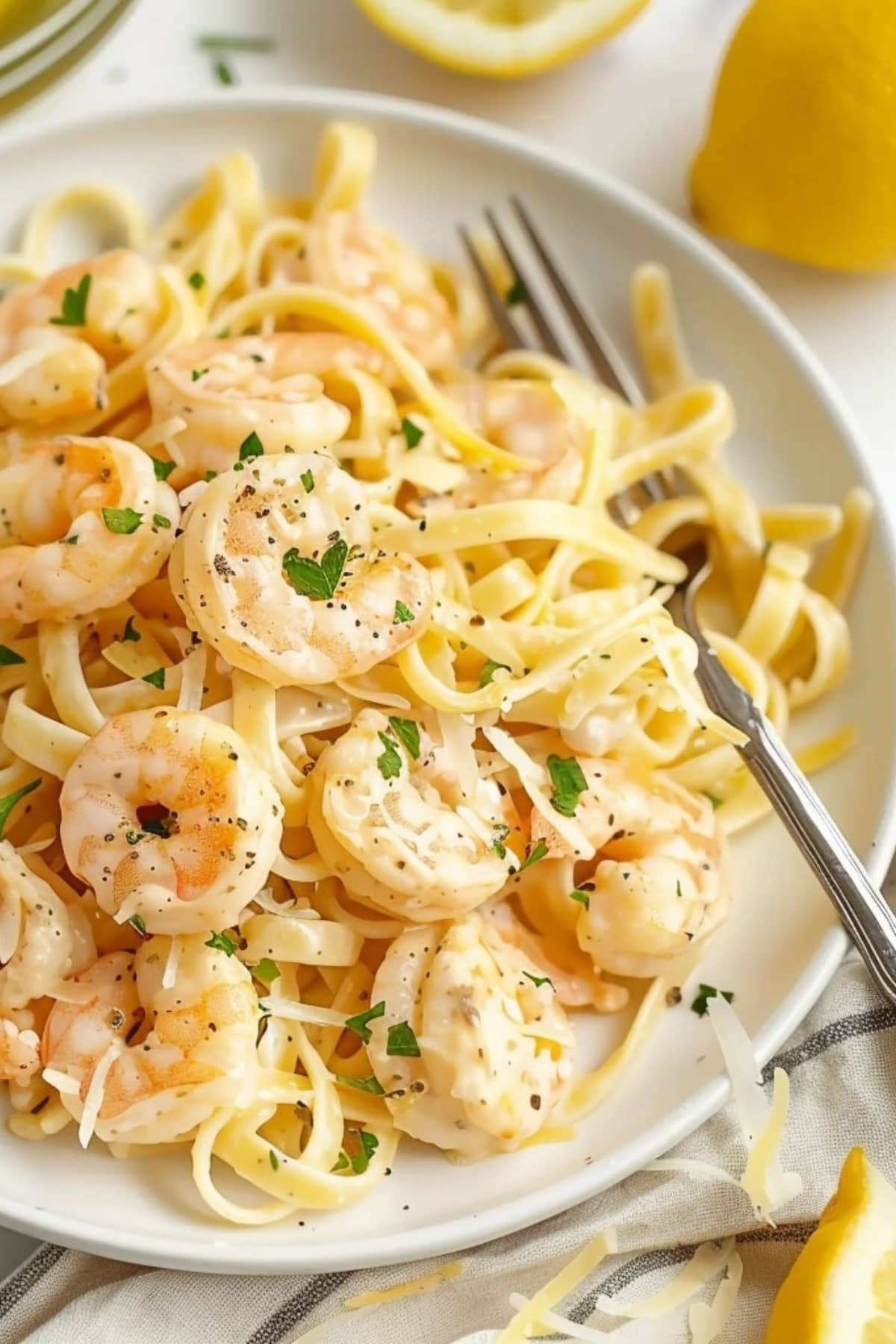Pasta with lemon sauce and shrimp on a white plate.