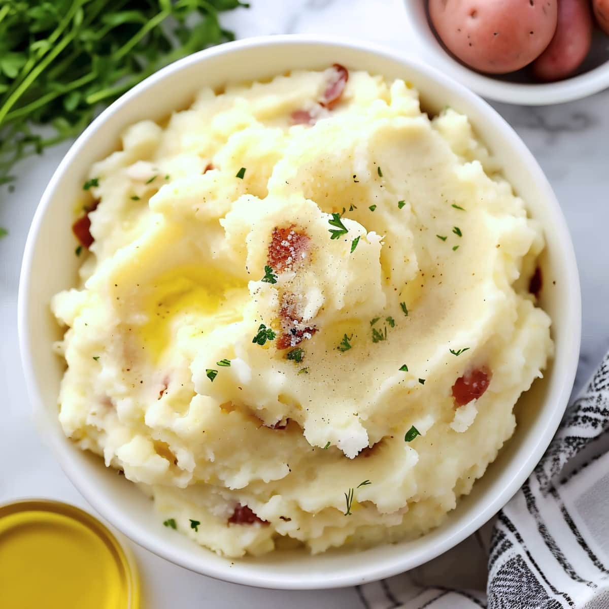 Bowl of homemade mashed red potatoes with bacon and herbs