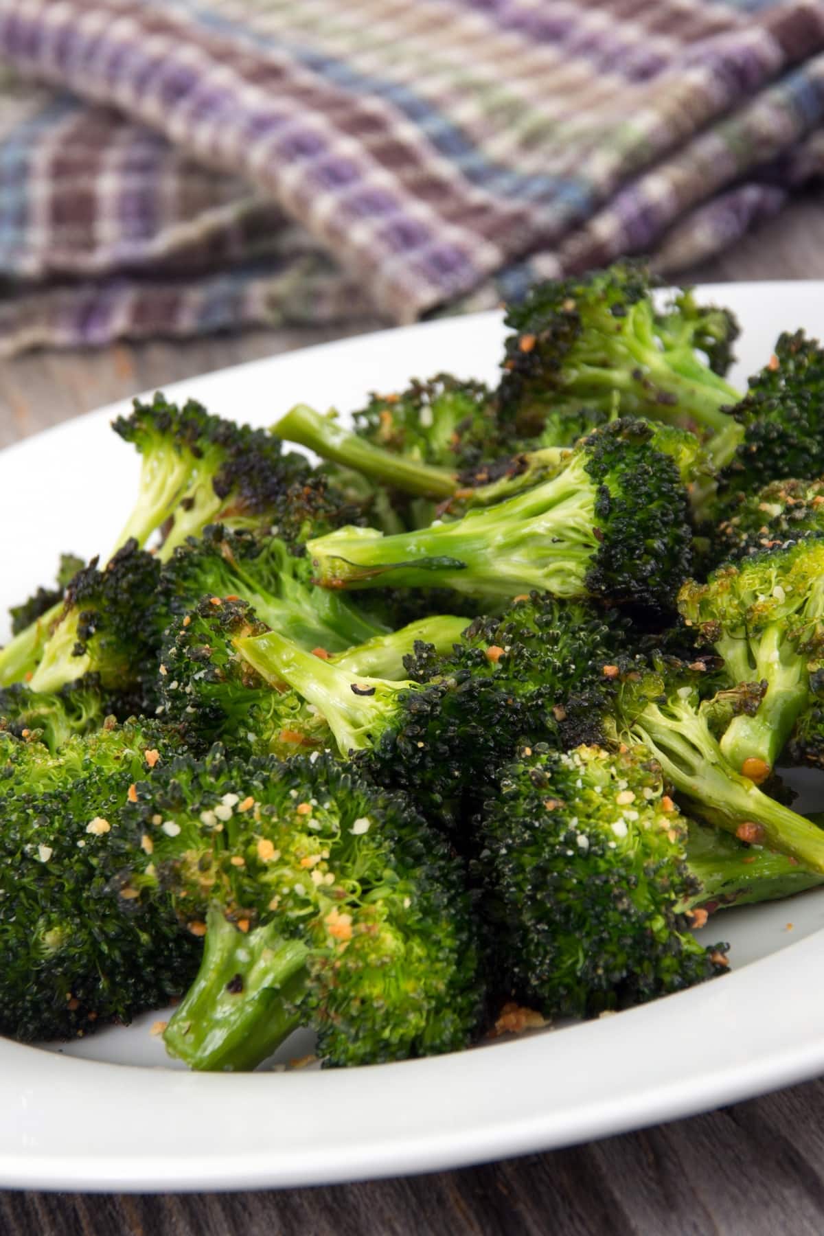 Roasted broccoli florets with parmesan cheese in plate.
