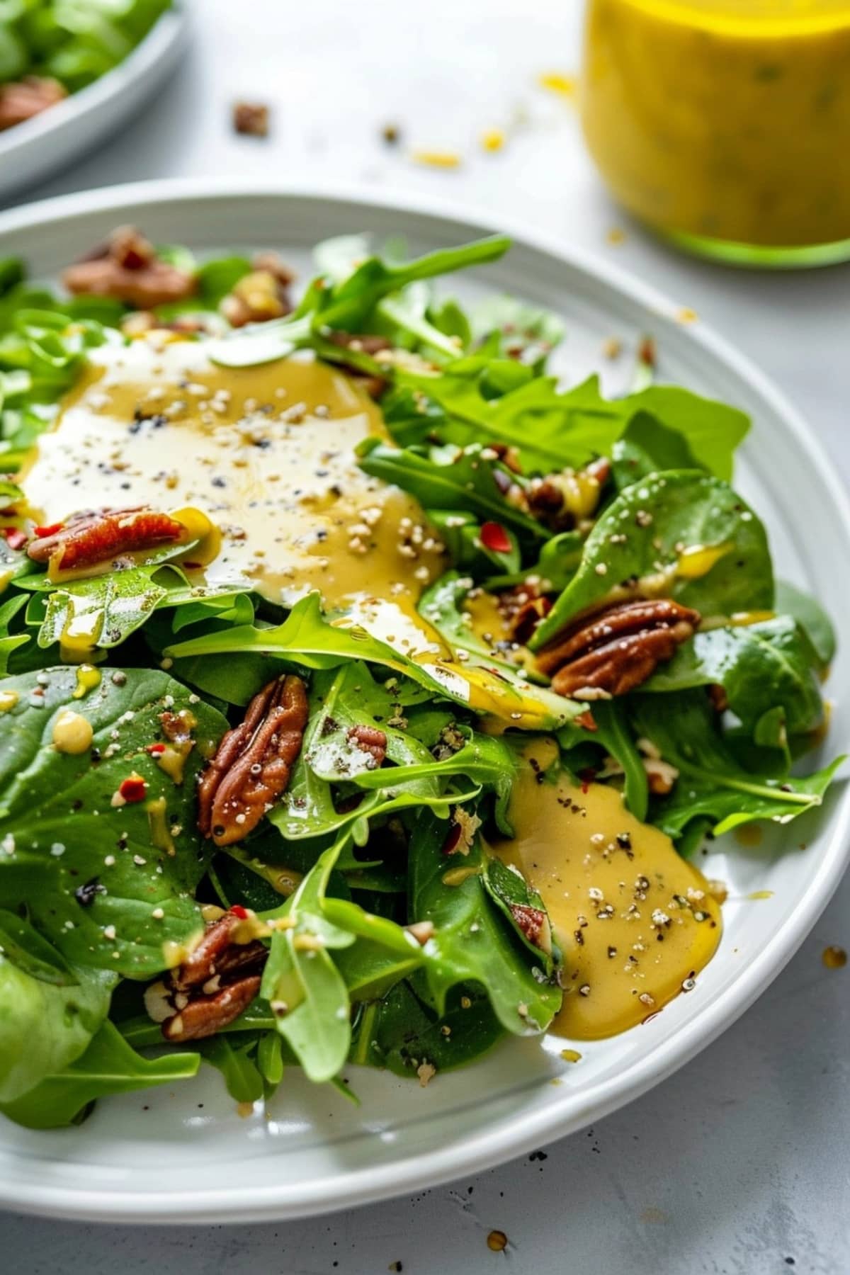 Honey mustard sauce drizzled over green salad in a plate.