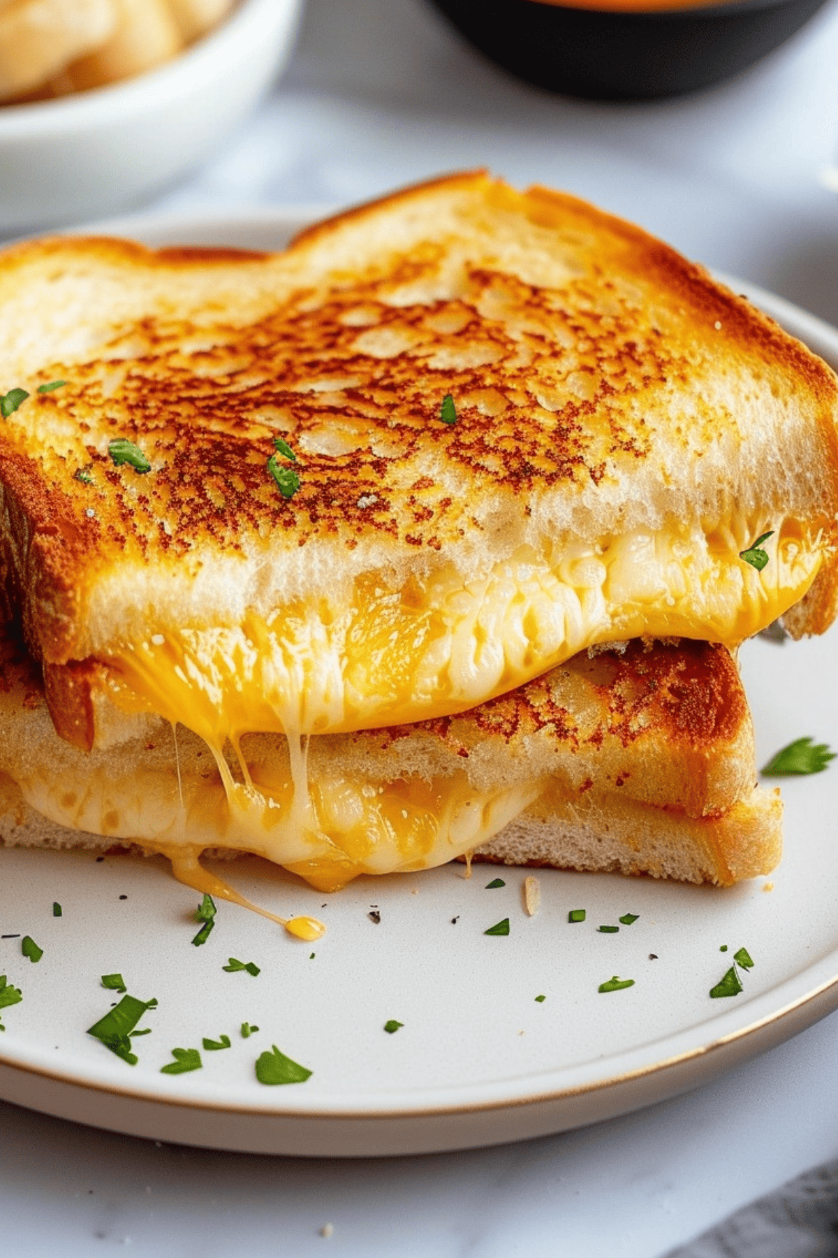 Sliced grilled cheese sandwich on a plate.