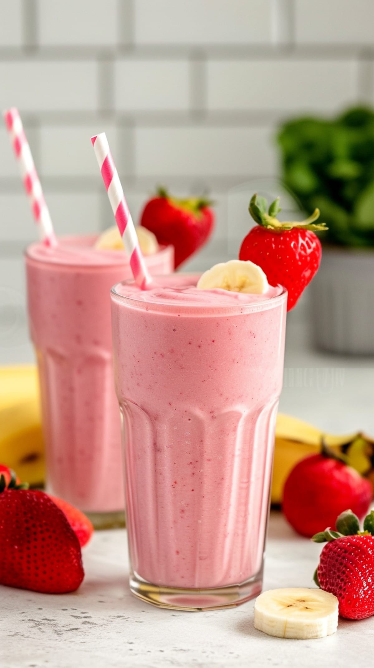 Strawberry Banana Smoothies in glasses with straws and fresh fruit