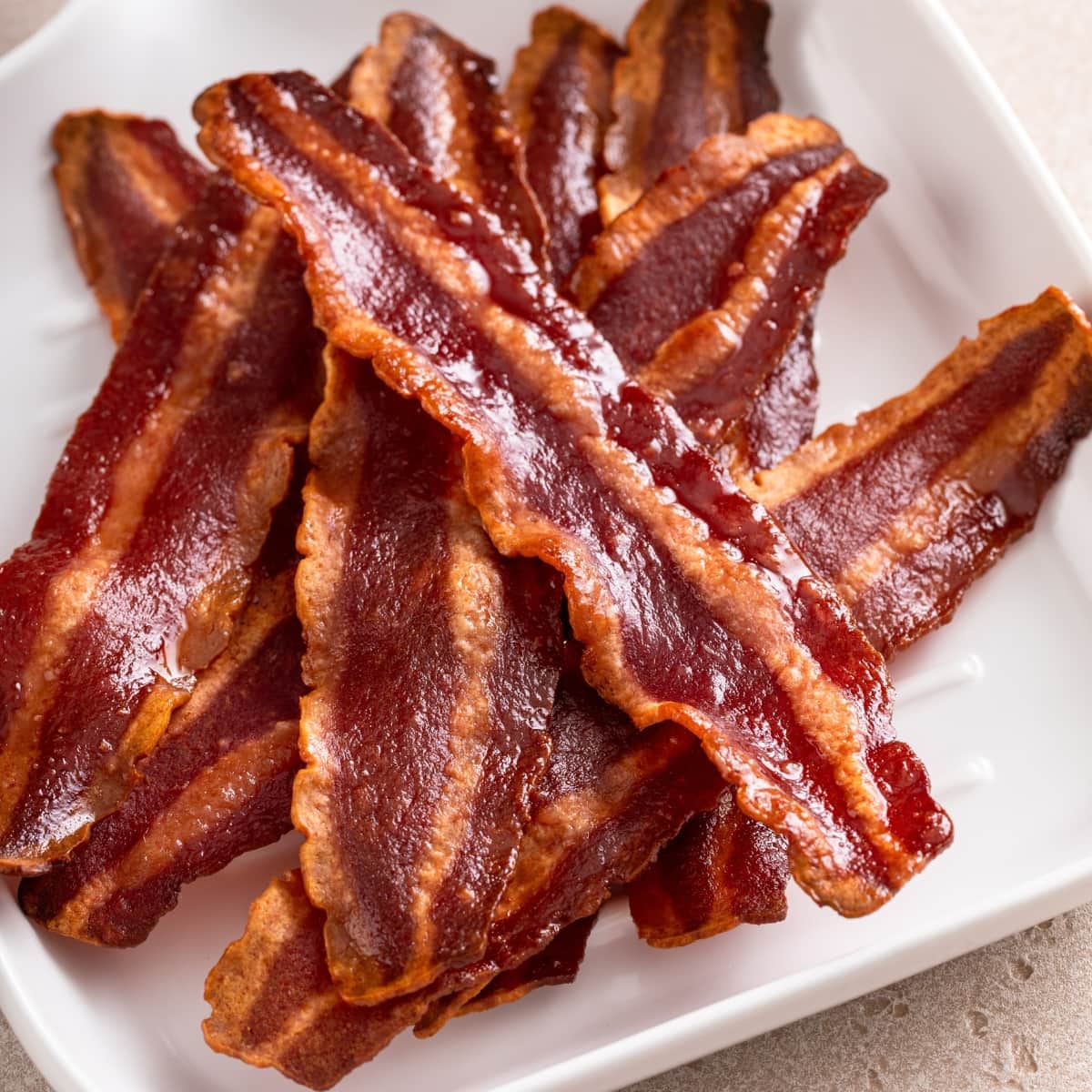 Strips of air fried Turkey bacon on a white plate.