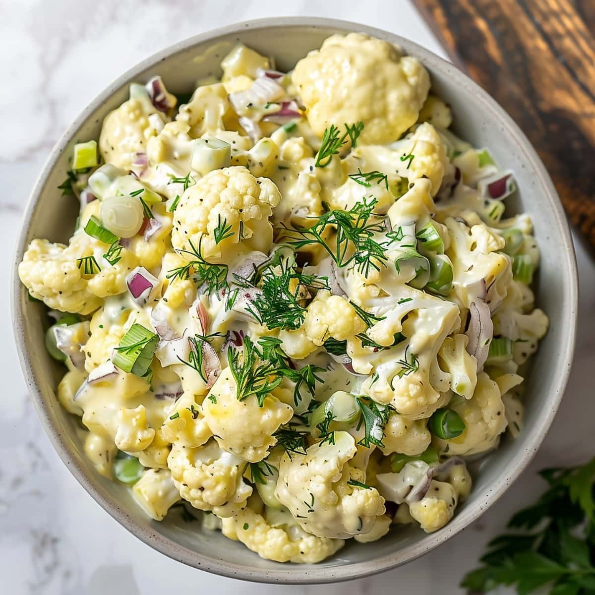 Top view shot of cauliflower potato salad with red onions, celery, and dill