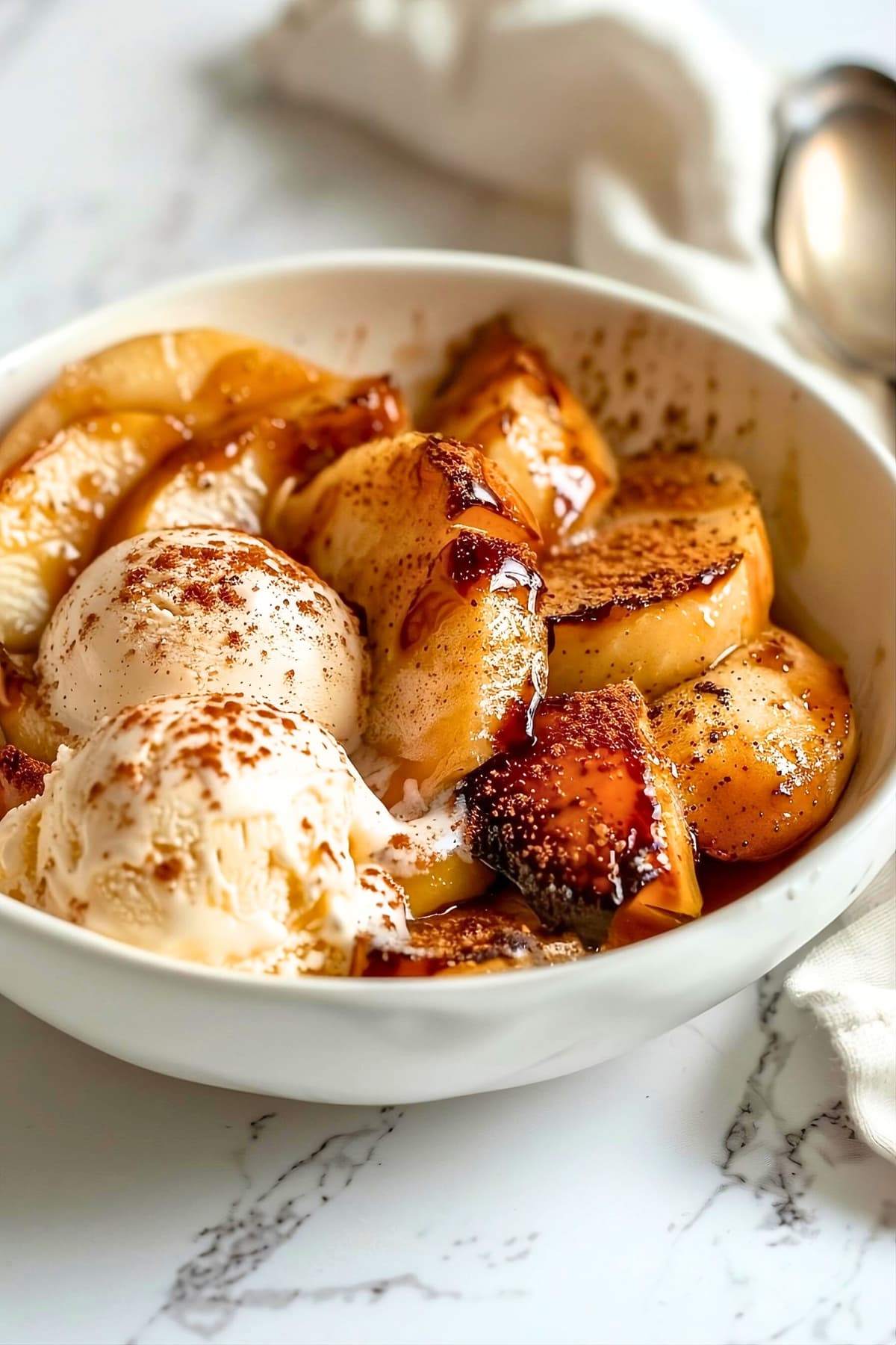 Baked apple with scoops of vanilla ice cream on bowl.