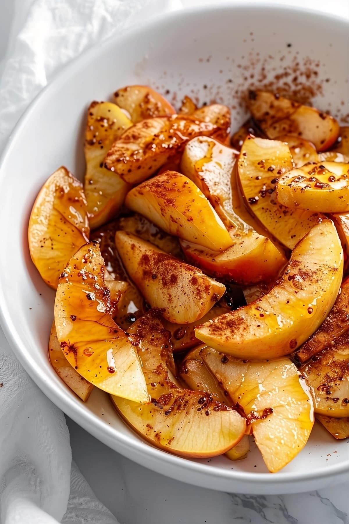Baked apples with cinnamon and sugar on a bowl.