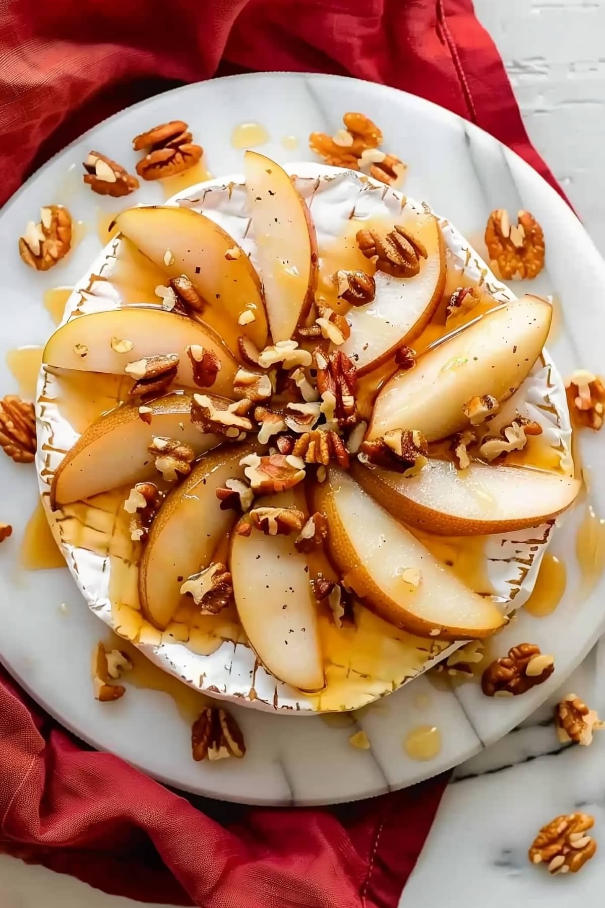Caramelized pear and baked brie with chopped walnuts, overhead view