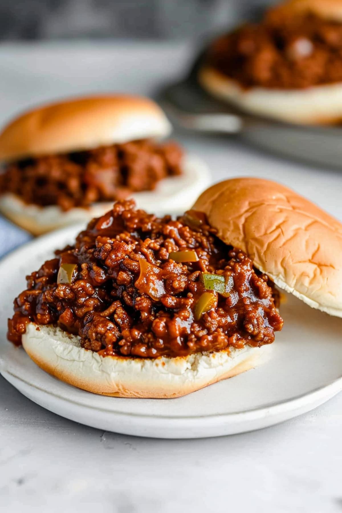 Classic barbecue joes on a plate with the top of the bun on the side