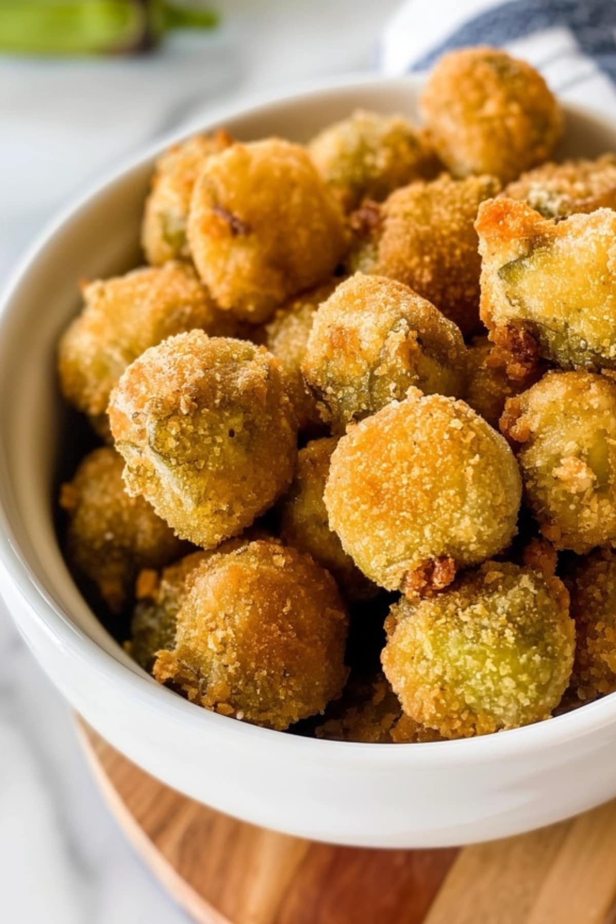 Coated fried okra in a white bowl.