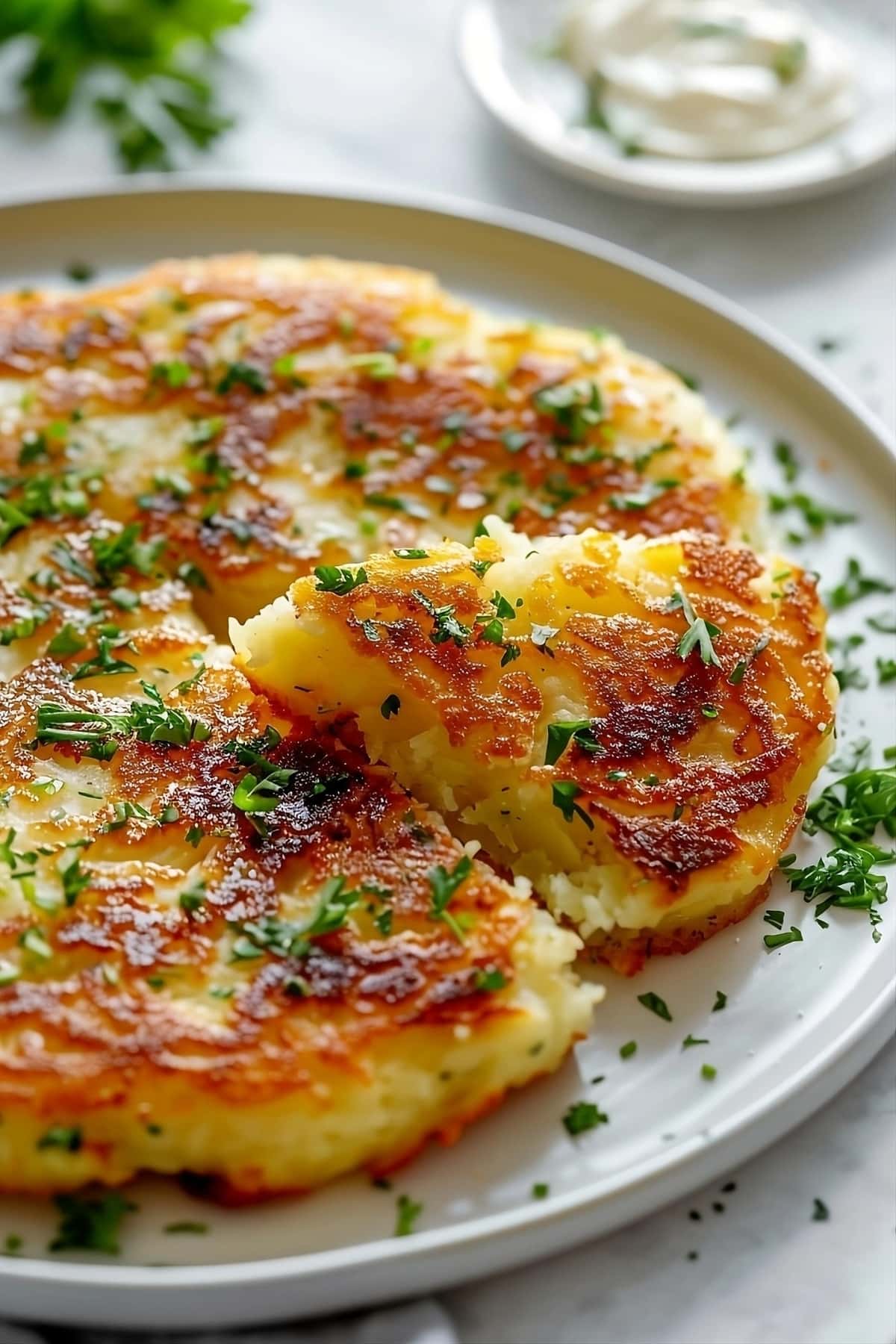Sliced bubble and squeak made with mashed potato and cabbage served on a plate.