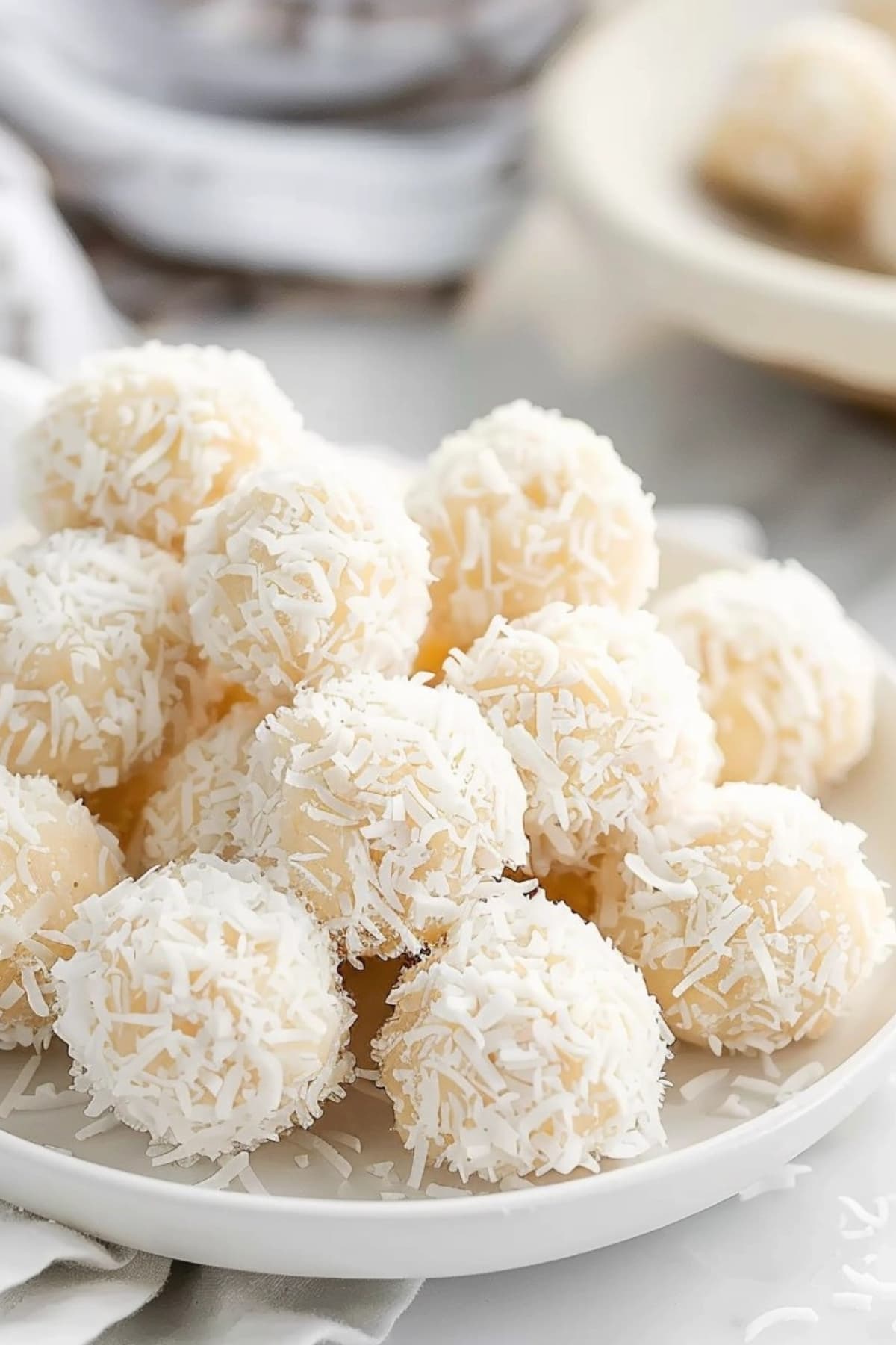 Pile of coconut snowballs in a white plate.