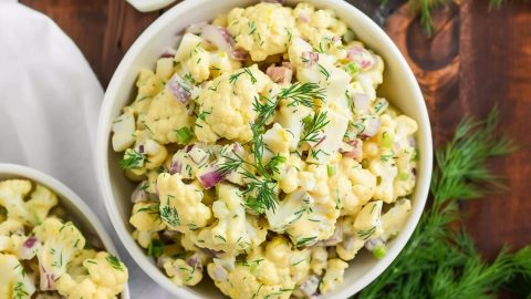 Top view of homemade healthy cauliflower potato salad in a wooden board