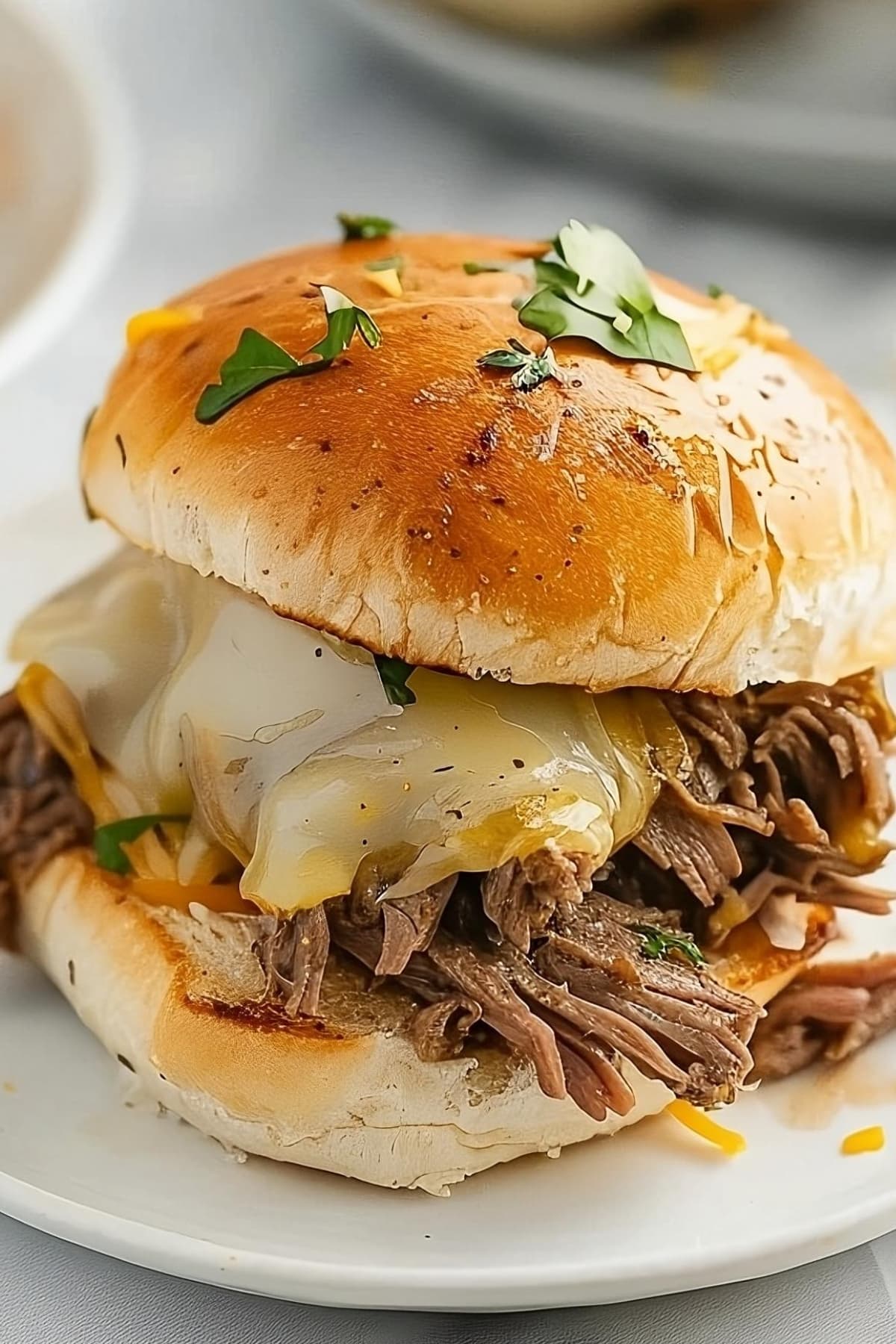 Piece of Philly Cheesesteak Sliders on a plate with melted cheese.